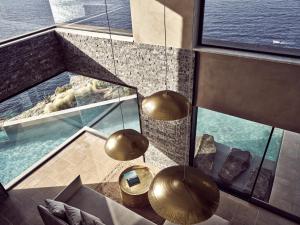 a room with a view of the water and two lights at Acro Suites - A Wellbeing Resort in Agia Pelagia