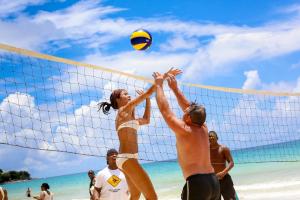 a group of people playing volley ball on the beach at Coral Strand Smart Choice in Beau Vallon