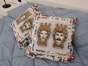 - un oreiller avec des visages sur le lit dans l'établissement Lucky House, à Marina di Ragusa