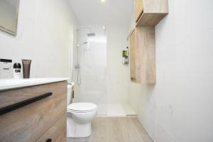 ein weißes Bad mit einem WC und einer Dusche in der Unterkunft Luxury Suite Fuengirola 1 in Fuengirola