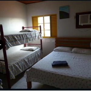 um quarto com 2 beliches e uma janela em Pousada Casarrara em Itaberaba