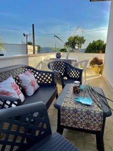 un patio con 3 sillas y una mesa con una bebida. en Villetta Claudia, en Castro di Lecce
