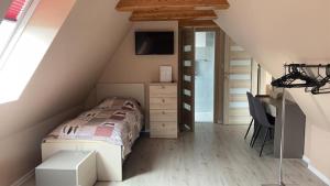 een slaapkamer op zolder met een bed en een bureau bij BALTIC VIBES - pokoje gościnne in Kołobrzeg