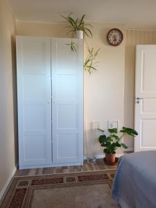 a bedroom with a white cabinet and a plant at Place to stay in Drøbak in Drøbak
