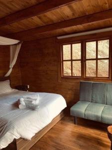 a bedroom with a bed and a chair and windows at Bosco Paradiso in Limassol