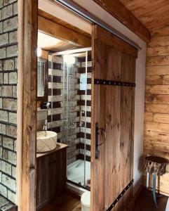 a bathroom with a glass shower and a wooden door at Bosco Paradiso in Limassol