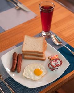 a plate of breakfast food with eggs sausage and toast at Burulu Inn in Gaafaru +28 photos