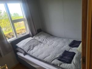 małe łóżko w pokoju z oknem w obiekcie Summer house - Fíflholt w mieście Hvolsvöllur