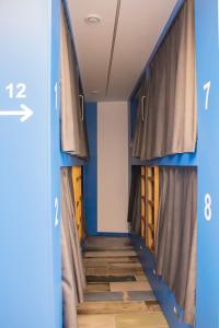 a hallway with blue walls and curtains and wooden floors at Albergue playa de sabaris in Sabaris