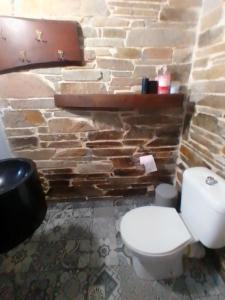 a bathroom with a white toilet and a stone wall at Thodis villa's in Karianí +56 photos