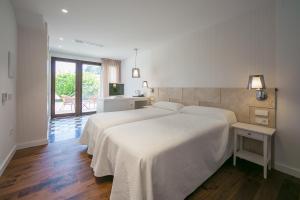 Un dormitorio con una gran cama blanca y un balcón. en Hotel Rural El Molino de Felipe, en Mula