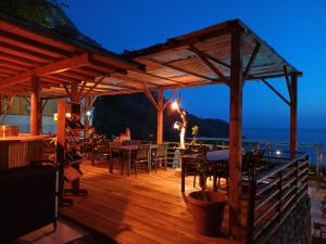 a wooden deck with tables and chairs at night at Tree Houses Hotel in Fethiye
