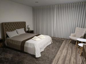 um quarto com uma cama e uma cadeira em Olhares do Lobo em Ponte da Barca