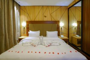 una camera da letto con un letto con rose rosse di Al Aseel Hotel a Doha Altre 26 foto