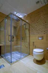 un bagno con doccia in vetro e WC di Al Aseel Hotel a Doha