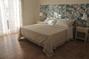 um quarto com uma cama com uma parede azul e cinzenta em Dimora Mariò em Marina di Mancaversa