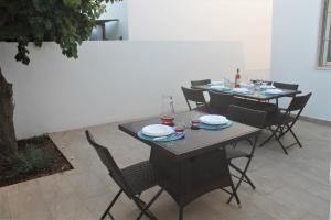 uma mesa com cadeiras e pratos em cima em Dimora Mariò em Marina di Mancaversa