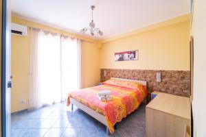a bedroom with a bed and a large window at Le Ville della Contea -Vacation rentals in Mascali