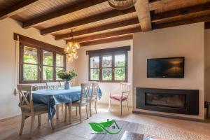 a dining room with a blue table and a fireplace at Vivienda Vacacional Villa Costa Cué in Cue