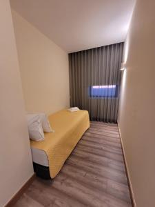 a small room with a bed and a window at APOLINÁRIO in Castrovicente