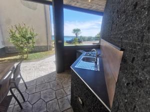 cocina con fregadero y vistas al océano en Apartma Auriga, en Portorož