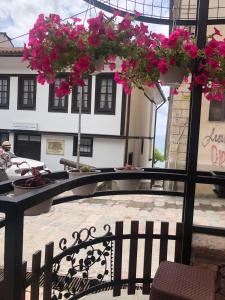 un patio con una mesa con flores rosas. en Apartments Lapidarium en Ohrid