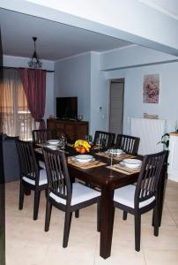 a dining room with a wooden table and chairs at Agis home in Agios Rokkos