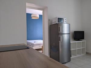 een keuken met een roestvrijstalen koelkast in een kamer bij Fouras - T2 Hyper centre les pieds dans le sable ! in Fouras
