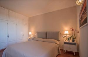 - une chambre avec un lit blanc et deux lampes dans l'établissement Suite Le Palme con terrazze in centro, à San Gimignano