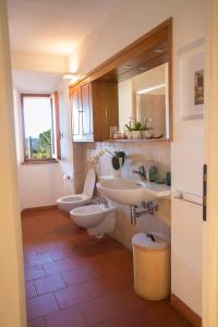 La salle de bains est pourvue de 2 lavabos et de 2 toilettes. dans l'établissement Suite Le Palme con terrazze in centro, à San Gimignano