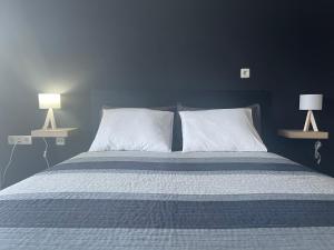 ein Bett mit zwei weißen Kissen und zwei Lampen in der Unterkunft Villa Nika in Valun