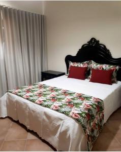 a bedroom with a large bed with red pillows at Herdade Monte Gordo in Ourique