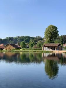 duży zbiornik wody z domami w tle w obiekcie Camping De La Sarre w mieście Abreschviller