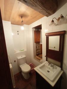 y baño con aseo blanco y lavamanos. en Casa de Abril 2, en San Cristóbal de Valdueza