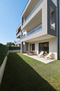 uma casa moderna com cadeiras e um quintal em Olive Residence em Zadar