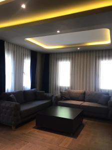 uma sala de estar com um sofá e uma mesa de centro em Kibar Suite Hotel em Uzungol