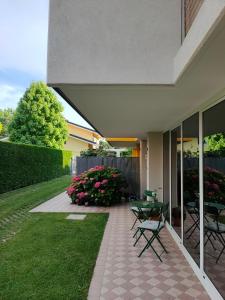eine Terrasse mit Stühlen, einem Tisch und Blumen in der Unterkunft A casa di Rosa in Padua