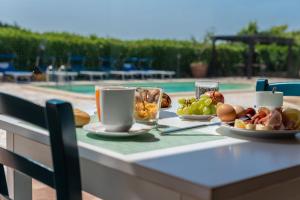 een tafel met borden en kopjes koffie bij Sisula Country Hotel & SPA in Orosei