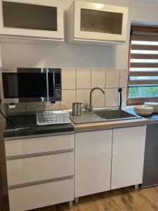 a kitchen with a sink and a microwave at BALTIC VIBES APARTAMENT in Kołobrzeg