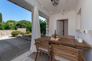 una sala da pranzo con tavolo e sedie in legno di Apartment Near Old Town, FREE PARKING & Huge Garden a Dubrovnik