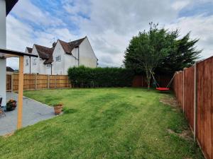 a yard with a fence and a house at Luxury Victorian Home Slough, Legoland, Windsor in Slough