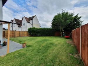 a yard with a fence and a house at St Georges house, Premium 3 bed Home Slough, Legoland, Windsor in Slough