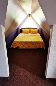 a bedroom with a bed in a small room at Casa de vacanță Dalia și Crina in Babadau