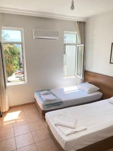 2 Betten in einem Zimmer mit 2 Fenstern in der Unterkunft Respect Apart otel in Alanya