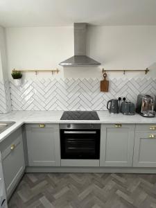 a kitchen with white cabinets and a stove top oven at Warwick Town Centre Property in Warwick