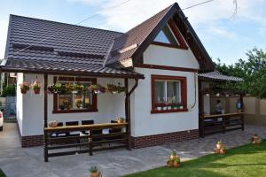 a small house with a bench in the yard at Casa de vacanță Dalia și Crina in Babadau