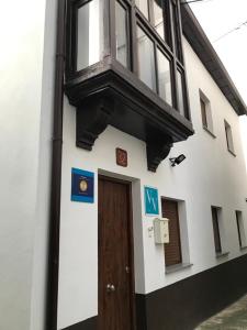 a building with a wooden door and a window at Narcea Turismo Real in Cangas del Narcea