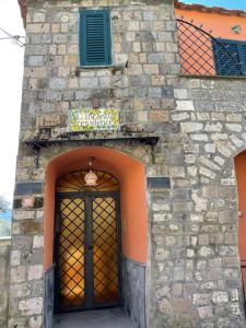 - un bâtiment en pierre avec une porte et un panneau au-dessus dans l'établissement Residence l'Incanto, à Piano di Sorrento