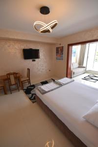 a bedroom with a large white bed and a flat screen tv at Apartments Daki in Igalo