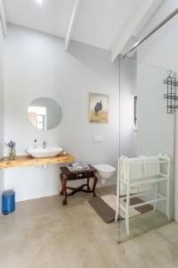 een badkamer met een wastafel, een toilet en een spiegel bij 20 Good Summers Farm Stay in The Crags